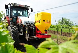 Einscheibenstreuer ES 100 M1 Classic an der Front des Traktors im Weingarten 